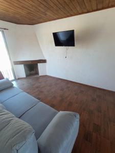 una camera da letto con un letto e una TV a schermo piatto di Solar de la Viuda a Punta Del Diablo