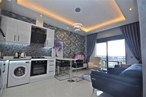 a kitchen and living room with a stove and a couch at Апартаменти в готельному комплексі in Alanya