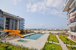 a swimming pool with a slide next to a building at Апартаменти в готельному комплексі in Alanya