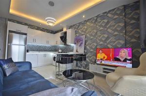 a living room with a blue couch and a television at Апартаменти в готельному комплексі in Alanya