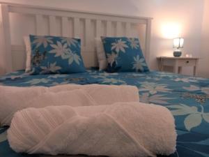 Un dormitorio con una cama con una manta. en Rose Velvet en Angra do Heroísmo