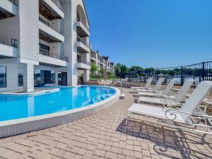 a swimming pool with lounge chairs next to a building at 117D Edgewater Inn in Charlevoix