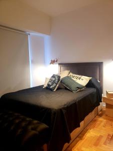 Un dormitorio con una cama con almohadas. en departamento luminoso y centrico en Mar del Plata