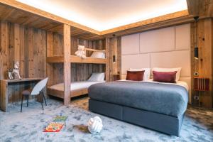 a bedroom with a bed and a bunk bed at Chalet Amis - Meribel - Pool moovie and play room in Méribel