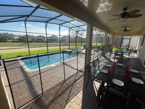 a screened in porch with a view of a swimming pool at Tropical Nights - 8 bed ChampionsGate Resort family pool home in Davenport