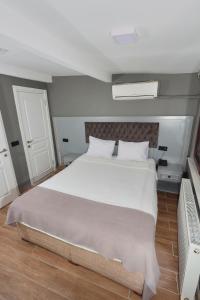 1 dormitorio con 1 cama grande con sábanas blancas en Ortakoy Aysem Sultan Hotel, en Estambul