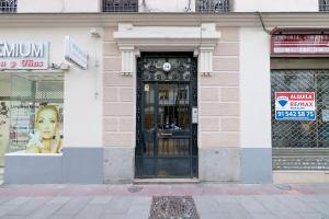 a store front with a black door on a street at BHost - Ferraz 74 in Madrid