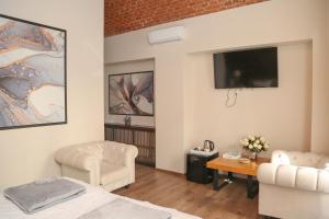 a bedroom with a bed and a tv and a table at ELEGANT ROOMS - ULTRACENTRAL - jacuzzi cu hidromasaj in Oradea