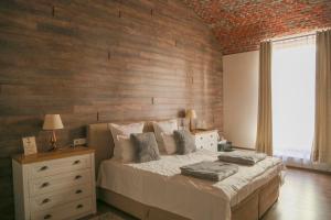a bedroom with a large bed and a brick wall at ELEGANT ROOMS - ULTRACENTRAL - jacuzzi cu hidromasaj in Oradea
