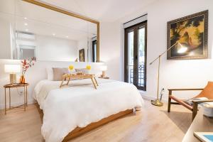 a white bedroom with a large bed and a table at BHost - Ferraz 74 in Madrid