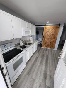 a kitchen with white cabinets and a wooden door at 125 Atlantic Avenue Unit K - Pet Friendly! Walk To The Beach and Pier! 1BR - 1BA -Sleeps 2-4 guests! in Myrtle Beach