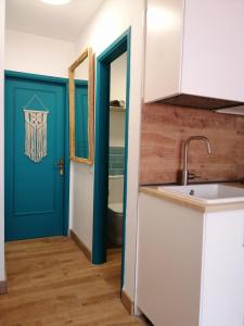 cocina con puerta azul y fregadero en Aguamarina Apartment - Los Diamantes 2, en Los Cristianos