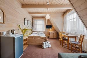 a bedroom with a bed and a table in a room at Willa Bystry, Pod Nosalem in Zakopane