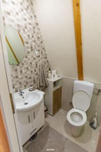 La salle de bains est pourvue de toilettes, d'un lavabo et d'un miroir. dans l'établissement Chalet Tupara attic, à Šišava
