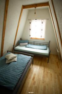 two beds in a small room with a window at Chalet Tupara attic in Šišava