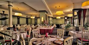 uma sala de jantar com mesas e cadeiras brancas em Hotel De La Paix em Lugano