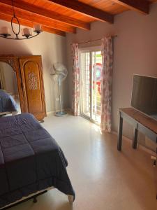 1 dormitorio con cama, escritorio y ventana en La Casa de Mabel en Villa Carlos Paz