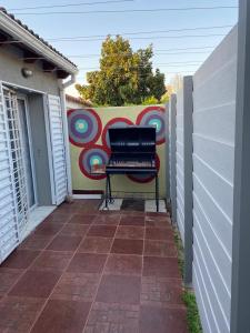 un banco sentado en un patio frente a una pared en La Casa de Mabel en Villa Carlos Paz