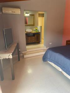 1 dormitorio con 1 cama y baño con lavamanos en La Casa de Mabel en Villa Carlos Paz