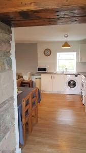 a kitchen and living room with a table and a stove at Cosy 2 Bedroom Croft Cottage with Beautiful Views in North Kessock