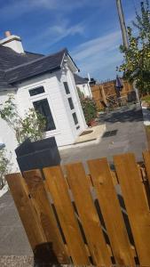 a wooden fence in front of a house at Cosy 2 Bedroom Croft Cottage with Beautiful Views in North Kessock