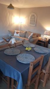 a blue table with four plates on it in a living room at Cosy 2 Bedroom Croft Cottage with Beautiful Views in North Kessock