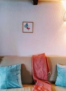 um sofá com duas almofadas e uma foto na parede em L'Azuré d'Ovronnaz em Ovronnaz