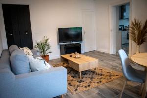 a living room with a couch and a coffee table at Gîte rénové avec piscine au cœur de Vendôme in Vendôme