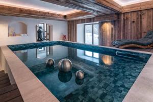 una piscina infinita en el medio de una casa en Chalet Amis - Meribel - Pool moovie and play room en Méribel