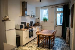 a kitchen with a table and a refrigerator and a microwave at Gîte rénové avec piscine au cœur de Vendôme in Vendôme