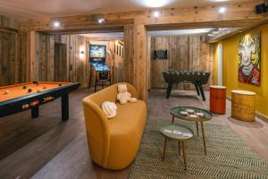una sala de billar con sofá y mesa de billar en Chalet Amis - Meribel - Pool moovie and play room en Méribel