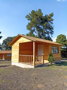 Cabaña de madera pequeña con porche en Rancho La Mesa, 