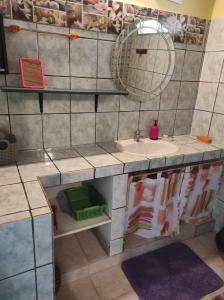 W łazience znajduje się umywalka i lustro. w obiekcie Chez Axel w mieście Le Marin