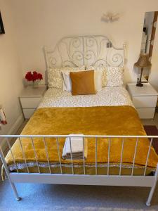 Charminster Homestay في بورنموث: غرفة نوم بسرير كبير مع اطار معدني