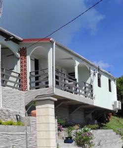 a white house with a porch and stairs at Chez Axel in Le Marin