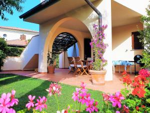 a house with a patio with flowers in the yard at Casa Eucalipto - Marina di campo, Elba in Marina di Campo