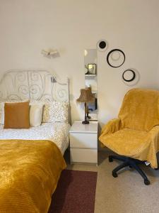 Charminster Homestay في بورنموث: غرفة نوم بسرير وكرسي