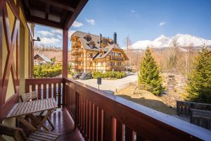 einen Balkon mit Blick auf eine Blockhütte in der Unterkunft Family Apartments Hotel Kukučka - Tatranská Lomnica in Tatranská Lomnica