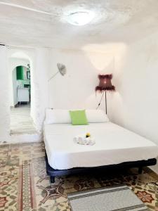 a white bedroom with a bed with a lamp on it at Apartamentos La Cueva in Paterna