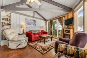 a living room with two chairs and a red couch at Slopesider 08 in Sugar Mountain