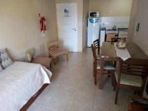 1 dormitorio con cama, mesa y cocina en Rivera Este en Colón
