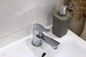 La salle de bains est pourvue d'un lavabo et d'un robinet. dans l'établissement Apartament w pełni wyposażony blisko centrum NETFLIX, à Inowrocław