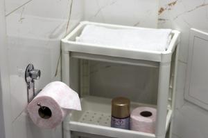 a white sink in a bathroom with toilet paper at Apartamenty w pełni wyposażone w CENTRUM MIASTA in Inowrocław