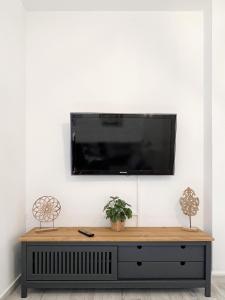 TV de pantalla plana colgada en una pared blanca en Casa Came - A/C+ WiFi - 1min Beach, en Arona