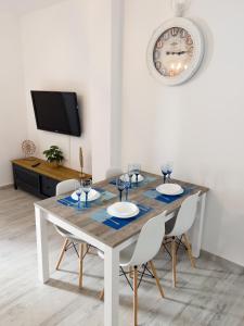 mesa de comedor con sillas y reloj en la pared en Casa Came - A/C+ WiFi - 1min Beach, en Arona