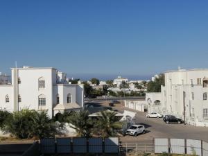 馬斯喀特的住宿－Muscat Homestay & Hospitality，享有停车场和白色建筑的景色