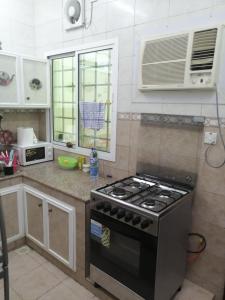 a kitchen with a stove top oven in a kitchen at Muscat Homestay & Hospitality in Muscat