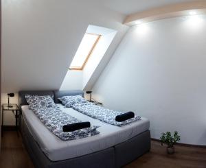 a bedroom with a bed with pillows and a window at Dream Apartman 1 with Free Parking in Győr