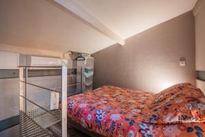 Dormitorio pequeño con cama con colcha de flores en Studio en Duplex-Aircon-Terrasse-Parking-Calme en Burdeos