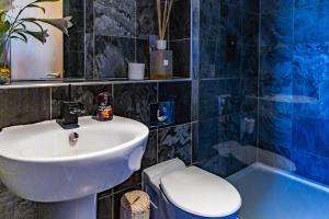 a bathroom with a sink and a toilet and a tub at Spacious 3-Bed Penthouse with City Sky Line Views in Sheffield